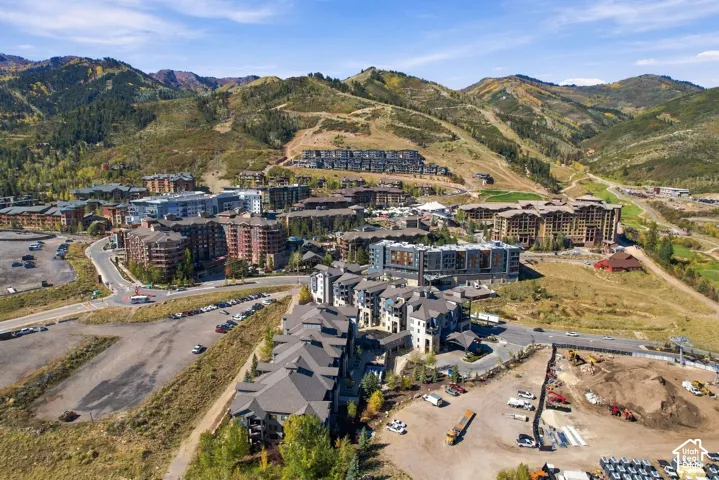 Aerial perspective of mountain landscape featuring multi-story residential architecture, stone-faced facades, pitched rooflines, and paved access roads