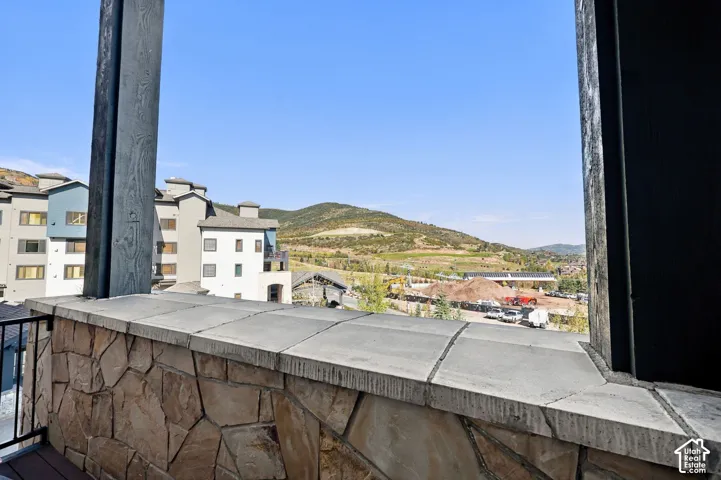 Private balcony featuring natural stone masonry, concrete tile cap, and metal railing