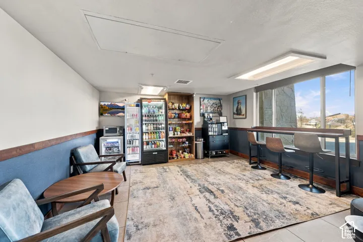 Common area featuring tile flooring, large windows, built-in shelving, and recessed lighting