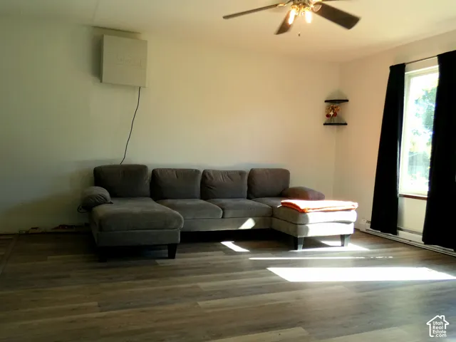 Wood-finish flooring, ceiling fan with integrated lighting, and large window