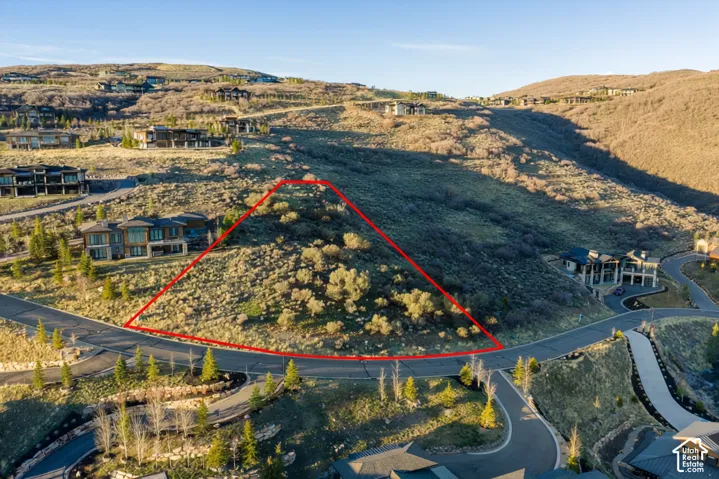 Elevated hillside lot featuring native vegetation, topographical slope, paved street access, and mountain terrain