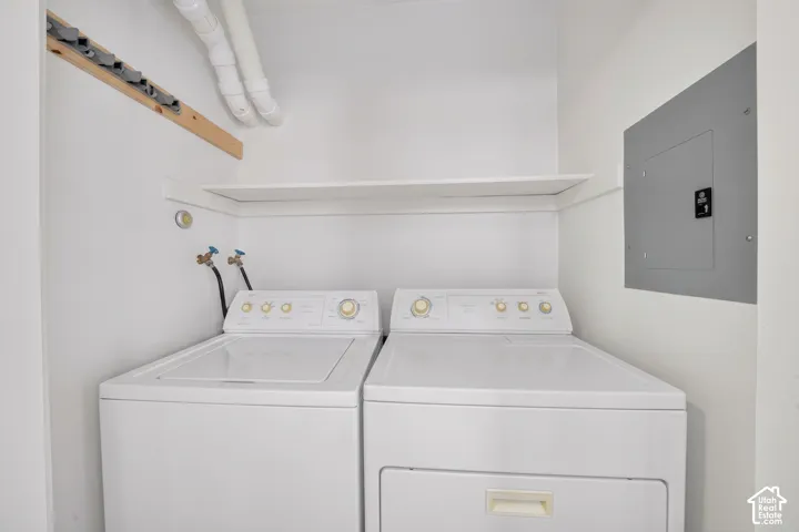 Laundry area featuring a built-in overhead shelf and recessed electrical service panel