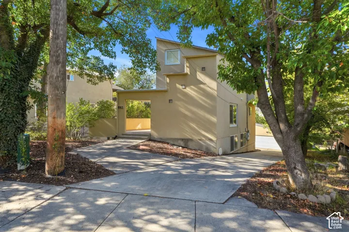 Contemporary exterior featuring a stucco facade, shed-style roofline, covered entry, and concrete driveway