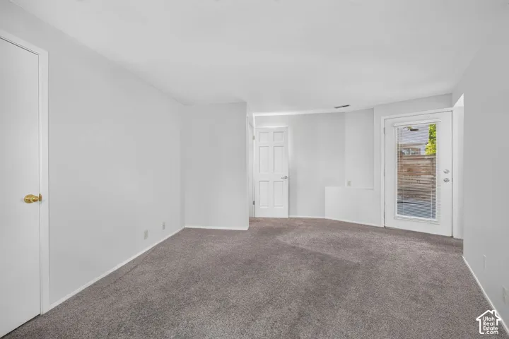 Neutral wall tones, gray carpeting, six-panel interior doors, and a glass-paneled exterior door