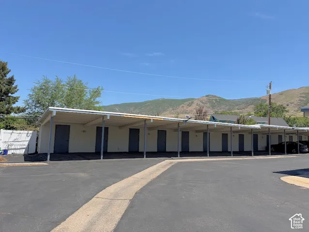 Covered parking structure featuring multiple storage units, metal roofing, and asphalt surfacing