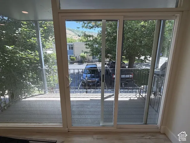 Sliding glass door with transom window, leading to a private balcony featuring metal railings and composite decking