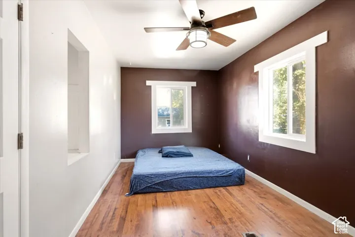 Wood-finish flooring, ceiling fan with integrated lighting, dual slider windows, and wall niche