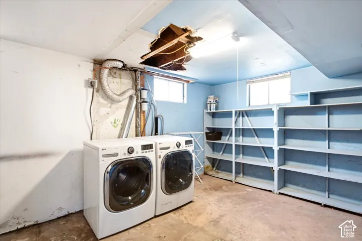 Utility space featuring built-in wooden shelving, two windows, and exposed ceiling structure