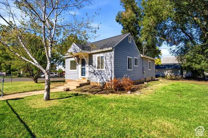 Single-story residence with lap siding, asphalt shingle roof, concrete front entry steps, and a grassy front lawn