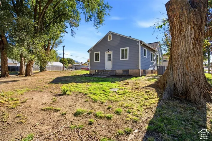 Single-story residence featuring lap siding, asphalt shingle roofing, multi-pane windows, and a concrete foundation with mature trees on the lot