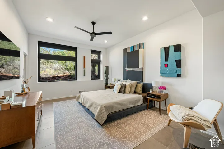 Large window installation with black frames, tile flooring, recessed ceiling lighting, and a modern ceiling fan