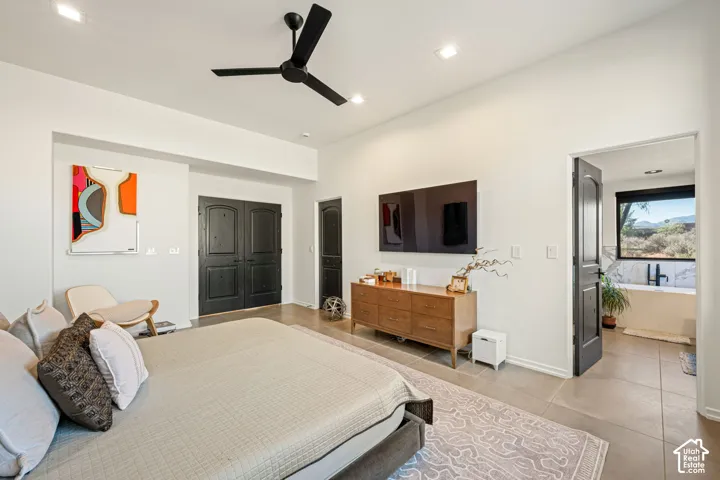 High-ceilinged room featuring matte black hardware, recessed lighting, a modern ceiling fan, and large-format neutral tile flooring