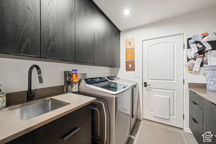 Laundry room featuring dark wood-finish cabinetry, stone-style countertops, an integrated drop-in sink with a matte black faucet, and recessed ceiling lighting