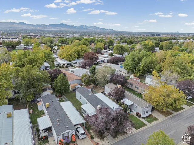 Aerial perspective featuring mature trees, paved streets, and expansive mountain scenery