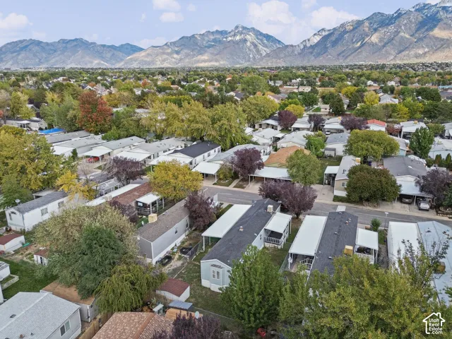 Aerial perspective featuring mountain backdrops and mature trees within the residential setting