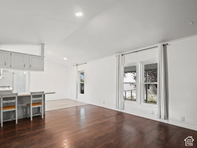 Vaulted ceilings, wood-finish flooring, recessed lighting, and built-in peninsula cabinetry