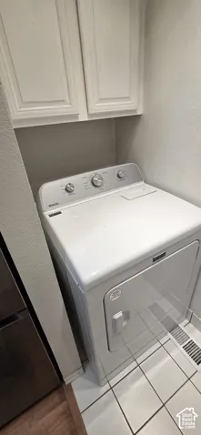 Built-in white overhead cabinetry and white tile flooring