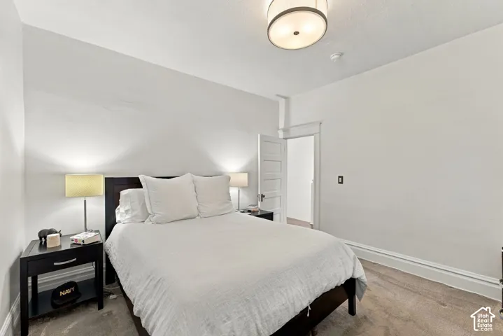 Neutral-toned wall finish, flush-mount circular ceiling lighting, and multi-panel interior door with traditional craftsman-style door casing