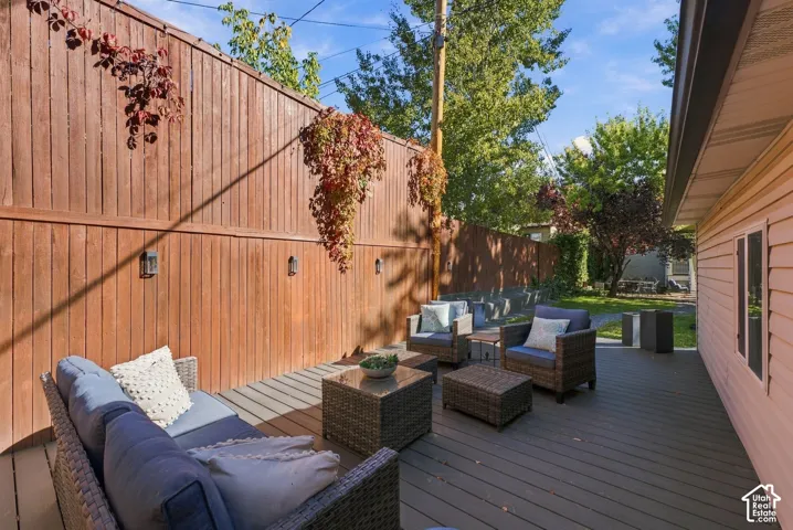 Composite wood deck featuring a full-height vertical wood privacy fence and integrated wall-mounted exterior light fixtures
