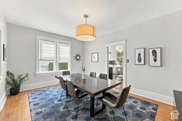 Hardwood flooring, neutral wall paint, classic window casing, and a drum pendant light fixture