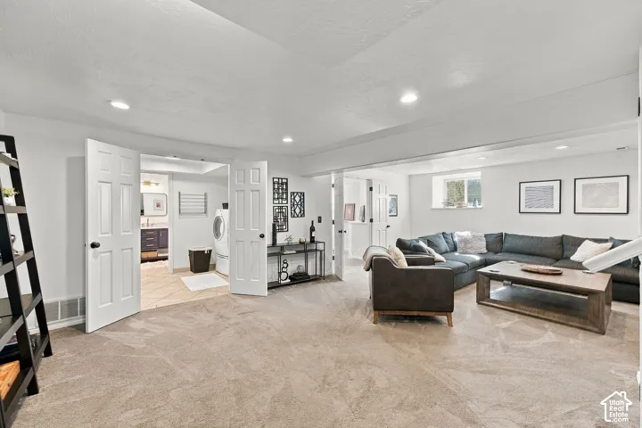 Open-concept area featuring recessed lighting, neutral wall-to-wall carpeting, multiple six-panel interior doors, and a natural light source via a slider window