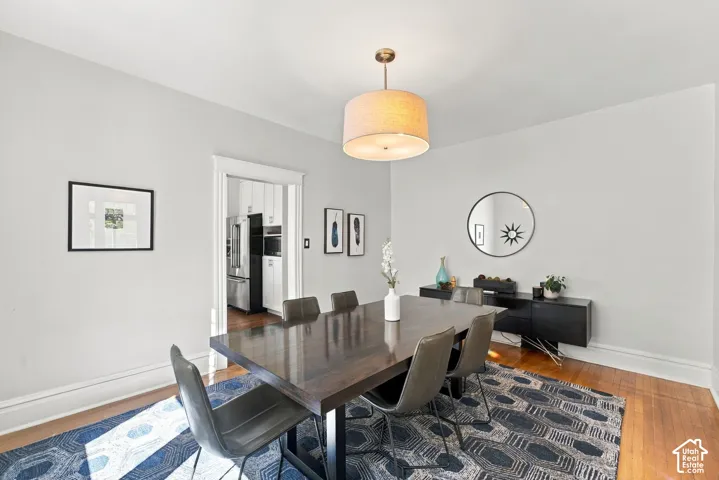 Hardwood flooring, drum-style pendant light fixture, and classic casing around the doorway