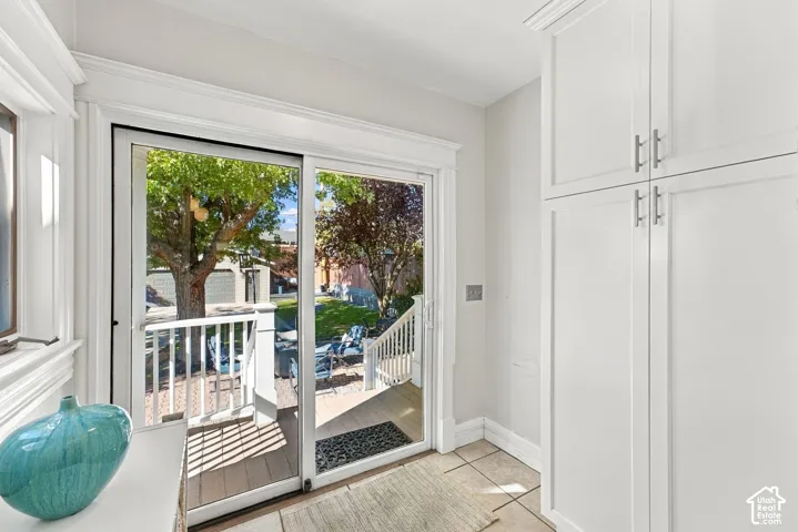 Full-height custom cabinetry with clean lines, sliding glass doors framed in decorative woodwork, and tile flooring