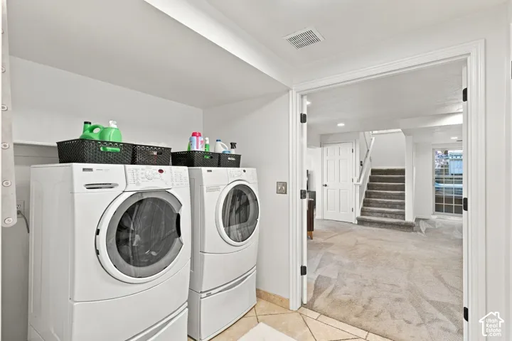 Laundry area featuring tile flooring, built-in shelving, and a double-door entrance