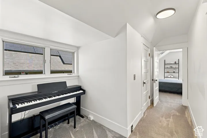 Sloped ceiling architecture featuring dual-pane windows, five-panel interior doors with brass hardware, and recessed circular lighting