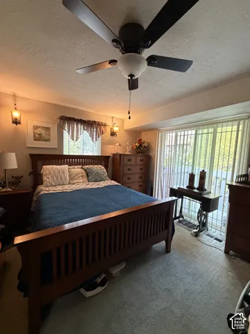 Multi-pane window, wall-mounted light fixtures, ceiling fan with integrated light, and sliding glass door with vertical blinds
