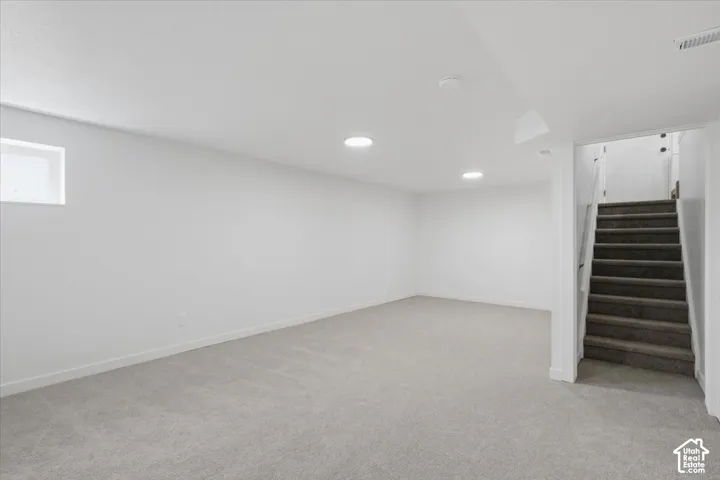 Open-concept interior space featuring wall-to-wall carpeting, recessed lighting, and a single window
