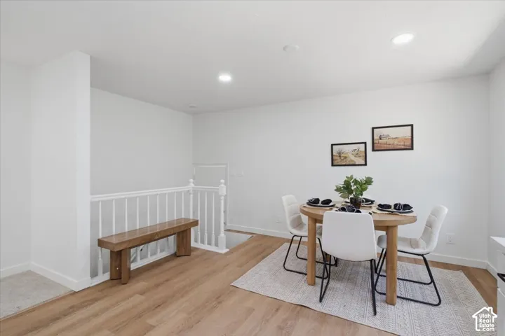 Open space featuring wood-finish flooring, recessed lighting, and a white balustrade railing