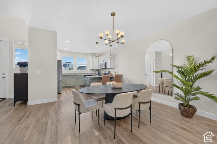 Wood-finish flooring throughout, with a contemporary chandelier and recessed lighting