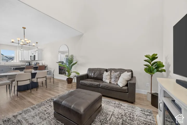 Vaulted ceilings, wood-finish flooring, and a modern linear chandelier