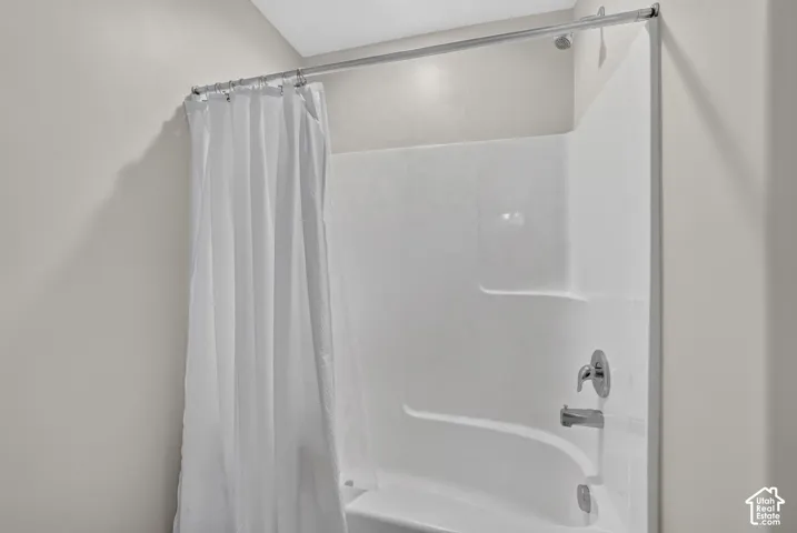 White acrylic tub and shower combination with chrome fixtures