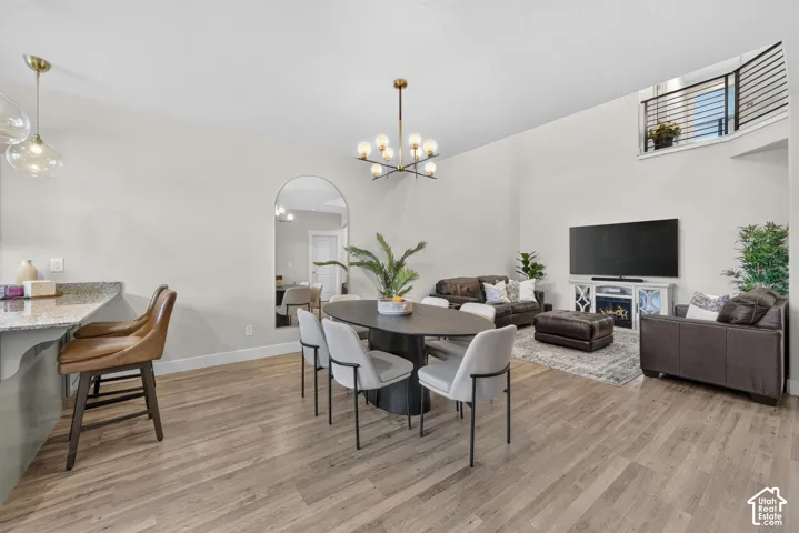 Wood-finish flooring throughout, a modern chandelier, and a built-in electric fireplace