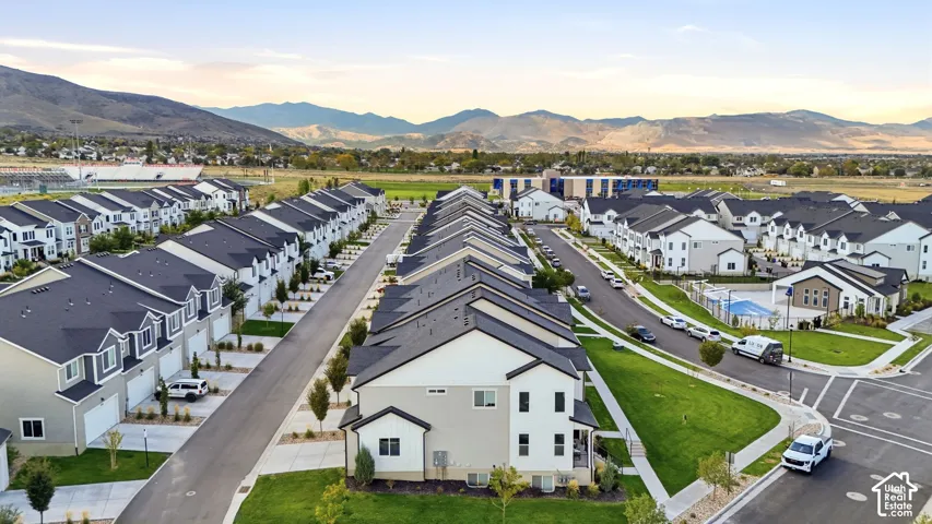 Community featuring uniform modern townhomes, mature landscaping, and a central pool area