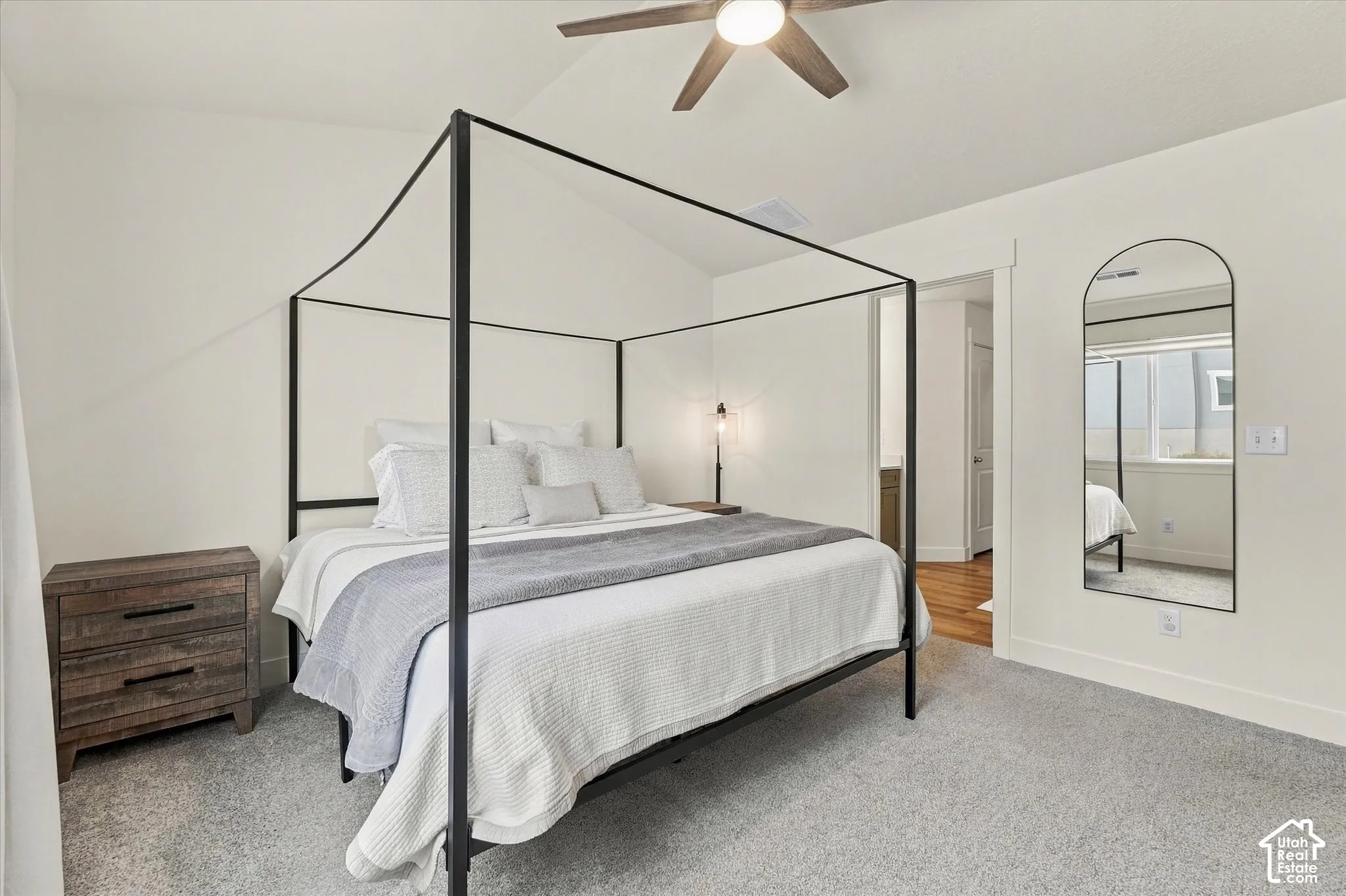 Bedroom featuring a vaulted ceiling, neutral wall coloring, carpeting, and a ceiling fan with integrated lighting