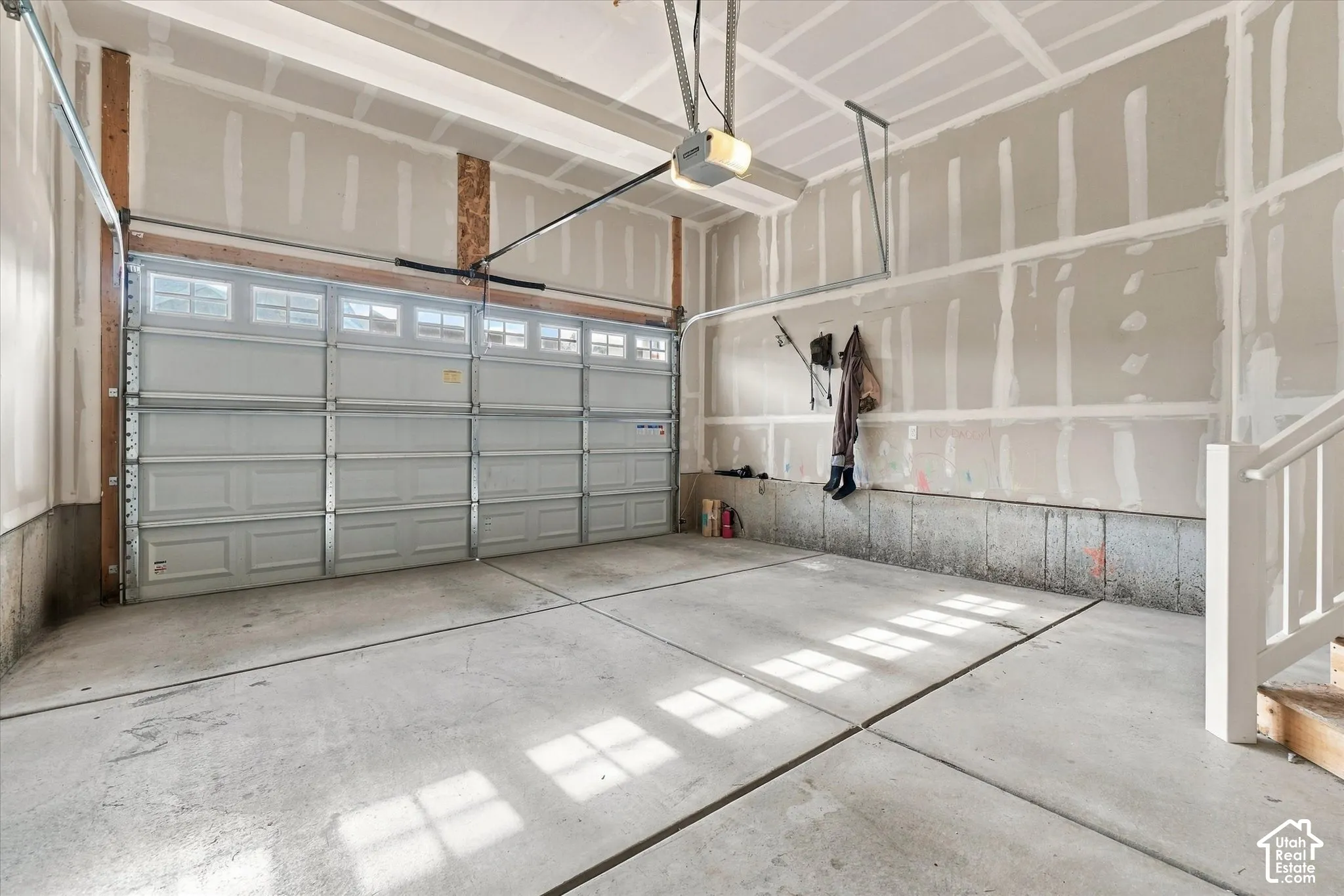 Multi-car garage featuring a sectional overhead door, concrete flooring, and an automated garage door opener