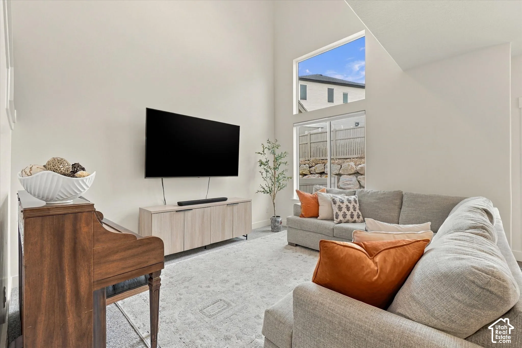 Living space featuring vaulted ceilings, floor-to-ceiling windows, and wall-mounted storage cabinetry