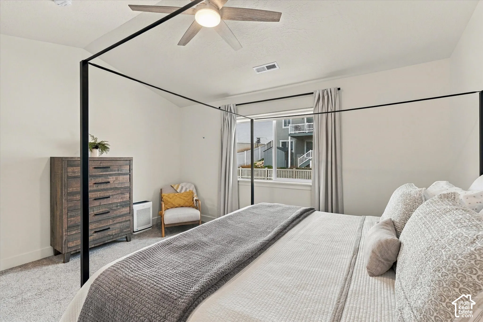 Neutral-toned carpeting, high ceilings, ceiling-mounted light fixture, and window with natural light