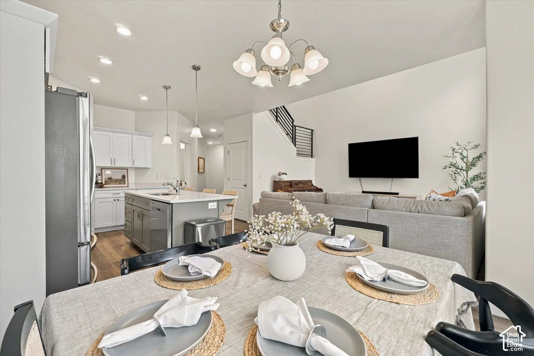 Open concept interior featuring a kitchen with white cabinetry, a center island, wood-finish flooring, recessed lighting, and a multi-light chandelier