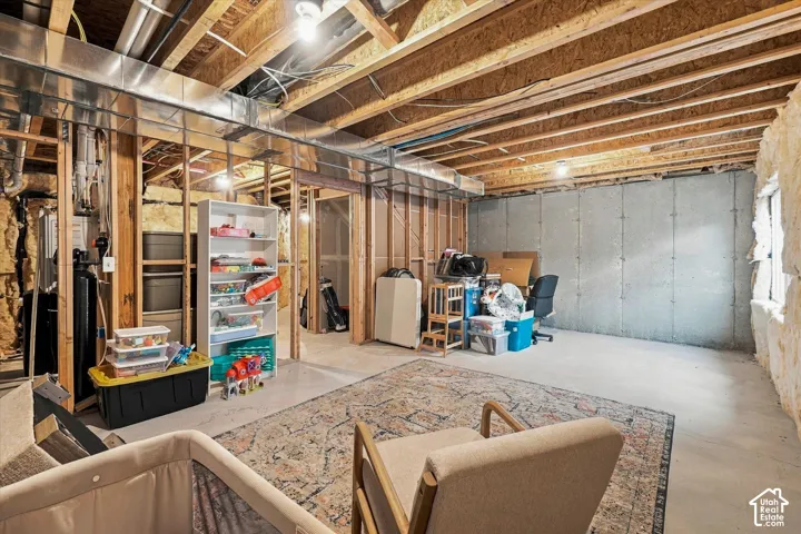 Unfinished space featuring exposed timber ceiling joists, concrete flooring, concrete foundation walls, and spray foam perimeter insulation