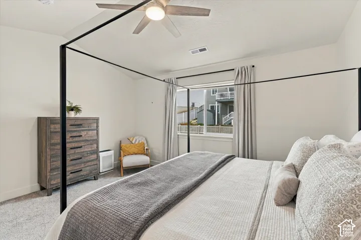Neutral-toned carpeting, high ceilings, ceiling-mounted light fixture, and window with natural light