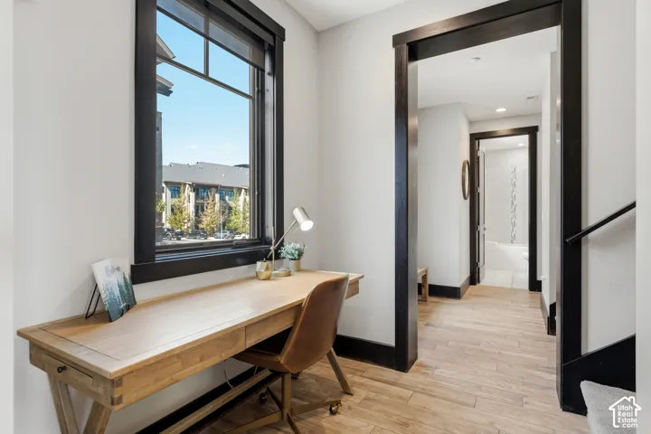 Interior space featuring wood-finish flooring, dark-stained wood door casing and window trim, and recessed ceiling lighting