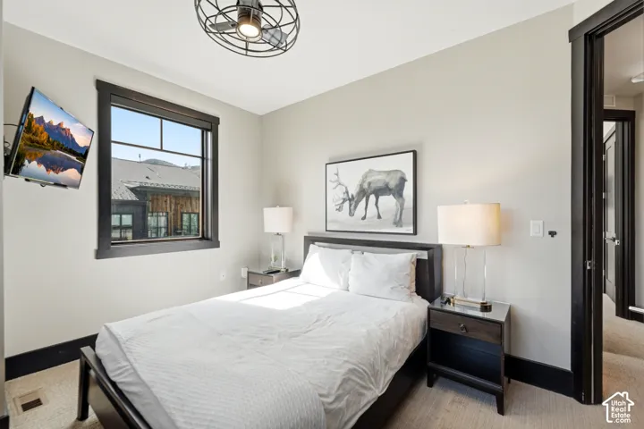 Neutral-toned interior featuring dark-finished trim and window casing, multi-pane window, and a metal industrial-style ceiling fan