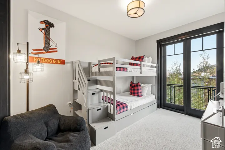 Floor-to-ceiling glass door with black trim, neutral carpeting, recessed ceiling lighting, and metal balcony railing