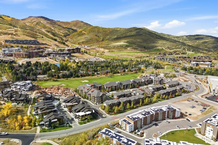 Aerial perspective showcasing mountain range topography, expansive green space, and multi-unit residential structures