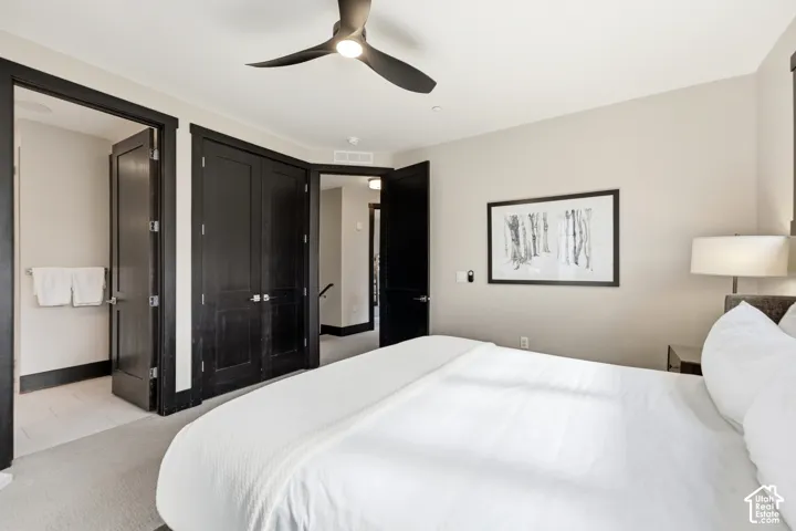 Neutral-toned interior featuring dark-finished interior doors and matching door casing, integrated ceiling fan with light fixture, and neutral carpeting