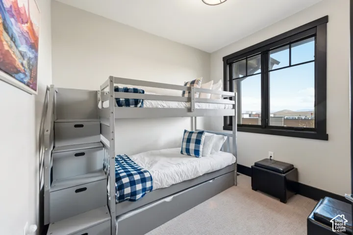 Neutral-toned interior featuring expansive window with contrasting dark trim and carpeting